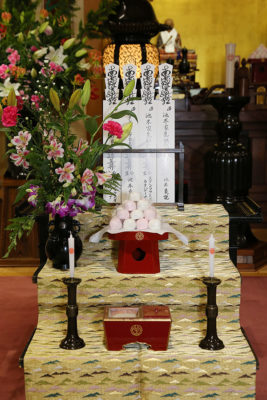 The altar devoted to our ancestors with the offering of sweets and the incense.