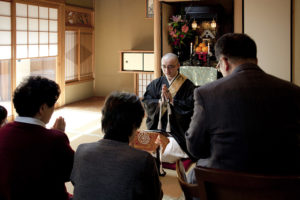 The officiating priest preaches a sermon at the end of a session of Oko.